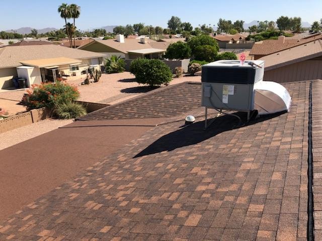 Architectural shingles installed on a Mesa Arizona home with AC unit and desert neighborhood view